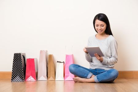 Mujer con bolsas de compras usando una tableta