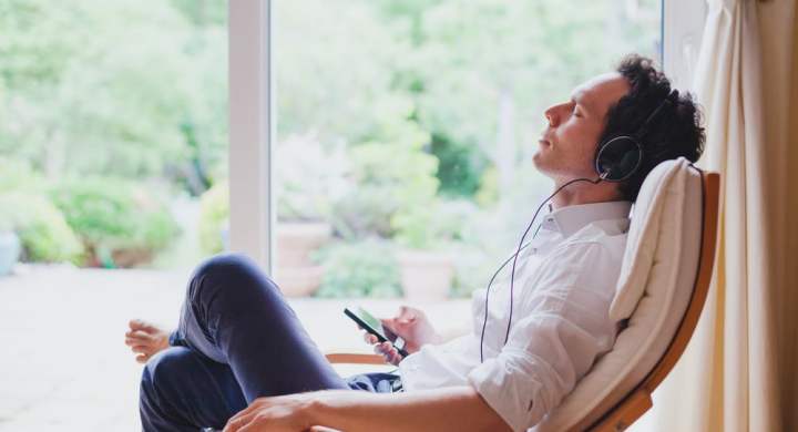 Hombre relajándose en casa escuchando música